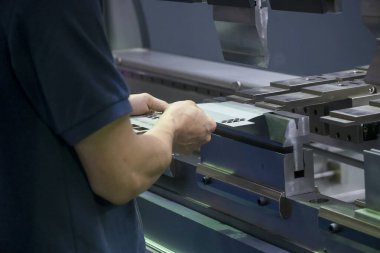 Teknisyenle hidrolik bükme makinesi operasyonu. Teknisyen ile bükme makinesi tarafından üretilen otomotiv levhası metal üretim süreci.