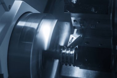CNC torna makinesi kanalı aydınlatma efektiyle metal makara parçalarını kesiyor. CNC dönüşüm makinesinin yüksek teknolojili metal işlemesi .