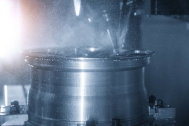 Üretim hattındaki magnezyum alaşımlı tekerlek parçaları. CNC değirmen makinesinin yüksek teknoloji otomotiv parçaları üretim süreci.