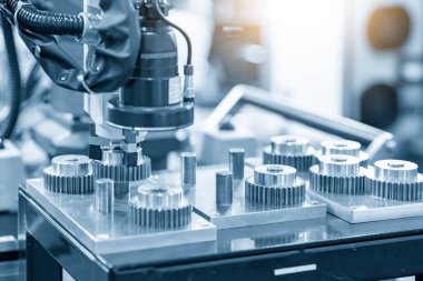 Robot kol metal dişli parçalarını topluyor. Otomotiv endüstrisi üretim süreci için malzeme işleme teknolojisi. 