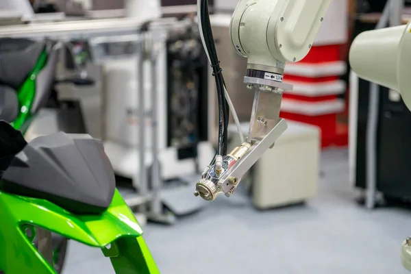 The painting robot spray the green color to the motorcycle mask parts. The automatic automotive parts painting system by robotics system.