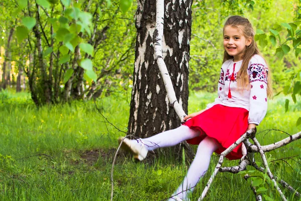 Menina no meio da plantação de flores e floresta de bétula — Fotografia de Stock