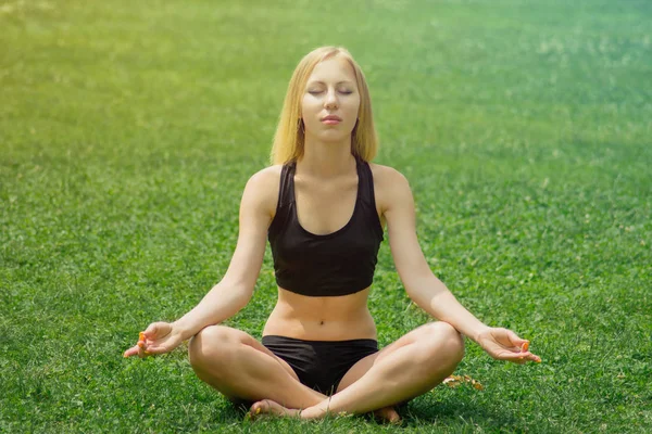 Yoga girl on green grass