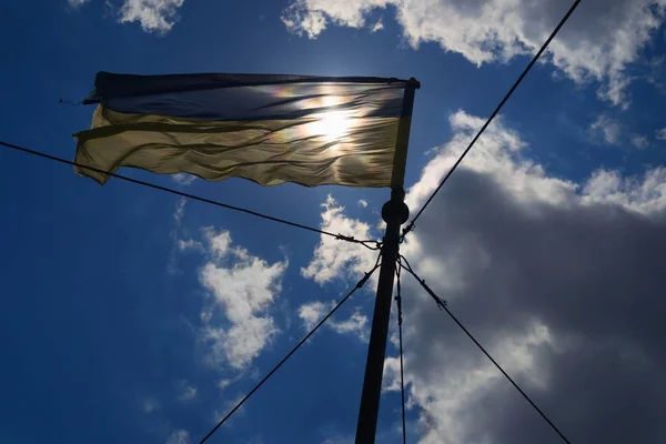 Ukrainian flag, hold by many ropes — Stock Photo, Image