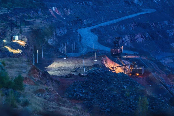 Máquinas de la industria pesada al atardecer trabajando en mina a cielo abierto — Foto de Stock