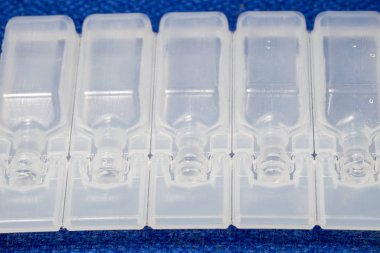 IV çözüm plastik şişe ampul mavi kumaş yüzeyinde.