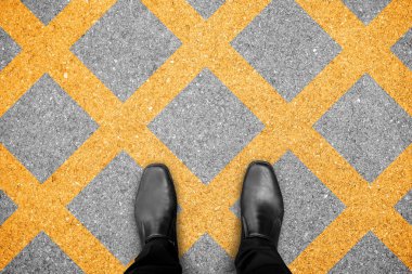 Siyah ayakkabılar hiçbir Park bölgesi üzerinde duruyor. Criss-cross sarı çizginin üstünde belgili tanımlık yol boyalı