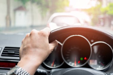 Sol tekerlek sürüş kontrol el araba. Trafik sıkışıklığı ve camın arkasından parlayan güneş ışığı