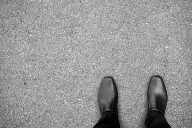 İşadamı asfalt beton zemin yapma kararına ne yapacağımı duran siyah ayakkabı