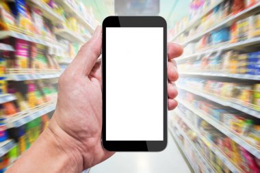 Bir supermartket içinde smartphone kullanarak. Koridor boyunca raf Snacks.