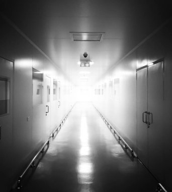 Sanayi koridor monoton siyah ve beyaz. Koridorun sonundan parlayan ışık.