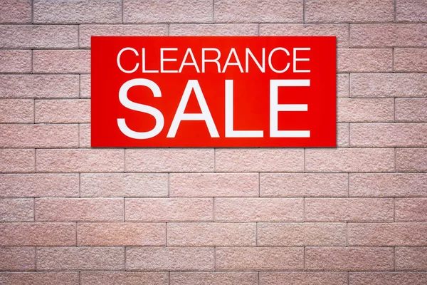 Red clearance sale billboard on brick wall