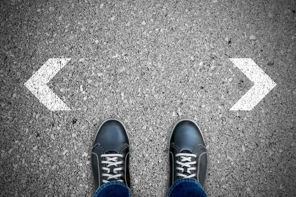 Black casual shoes standing at the crossroad making decision which way to go.