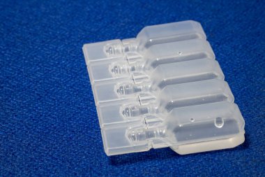 IV çözüm plastik şişe ampul mavi kumaş yüzeyinde.