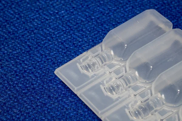 IV çözüm plastik şişe ampul mavi kumaş yüzeyinde.