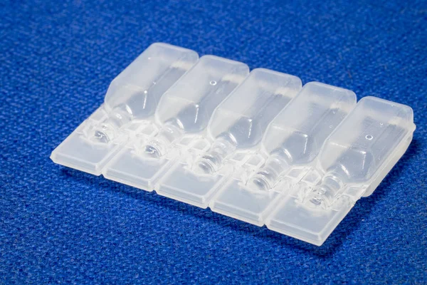 IV çözüm plastik şişe ampul mavi kumaş yüzeyinde.