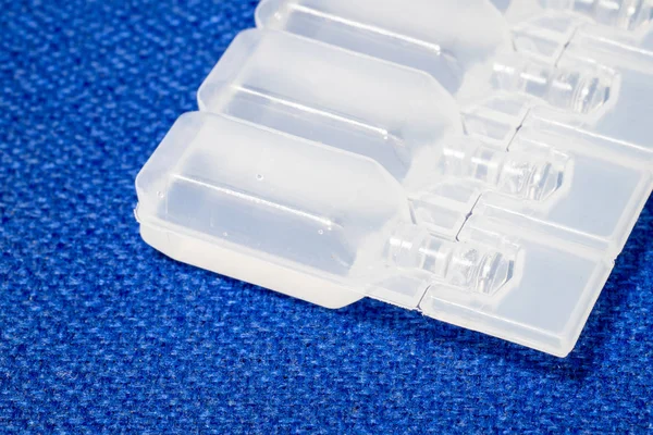 IV çözüm plastik şişe ampul mavi kumaş yüzeyinde.