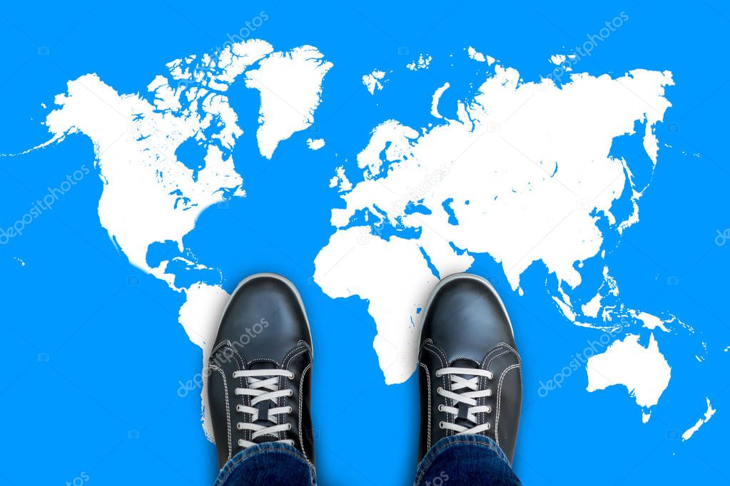 Black casual shoes standing on world map start making his journey around the world.