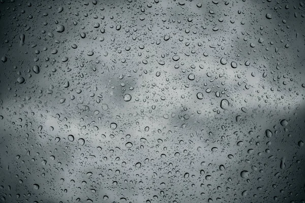 透明なガラス窓と曇りの暗い空の背景の窓の外の嵐の後の水滴 — ストック写真