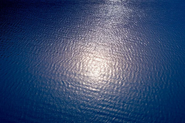 Resumen borroso reflejo del sol sobre el agua en el lago — Foto de Stock