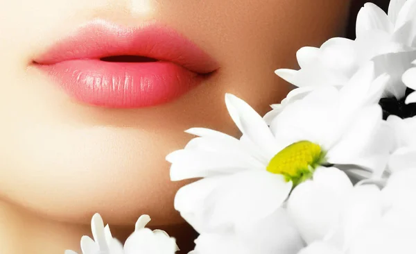 Lábios com flor. Close-up belos lábios femininos com lábio brilhante — Fotografia de Stock