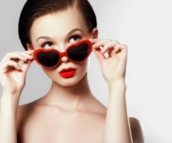 Young girl with glasses in the shape of heart. Holiday makeup — Stock Photo, Image