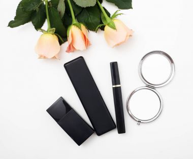 Dekoratif düz kozmetik ve çiçekler kompozisyonu yatıyordu. Beyaz arka plan üzerinde Üstten Görünüm