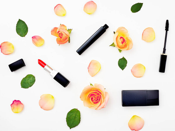 Декоративная плоская композиция с косметикой и цветами. Вид сверху на белый фон
