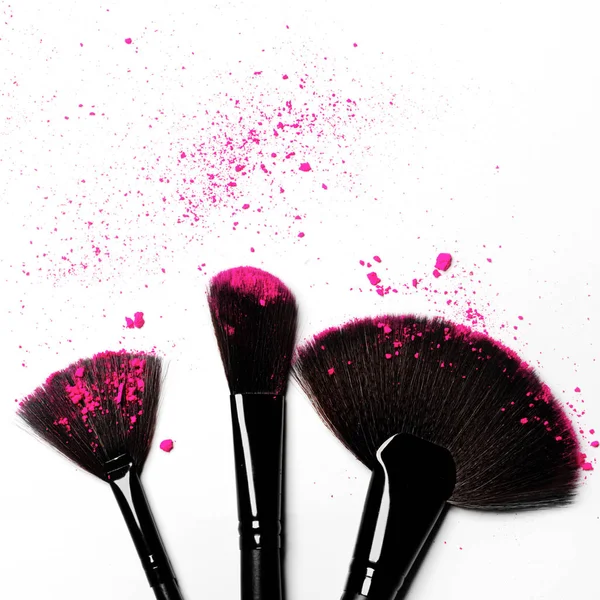 Makeup brushes on white background with colorful pigment powder — Stock Photo, Image