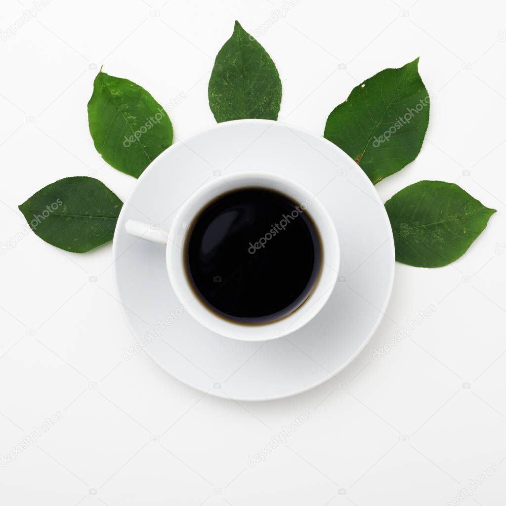 Top view of coffee on white background with fresh leaves
