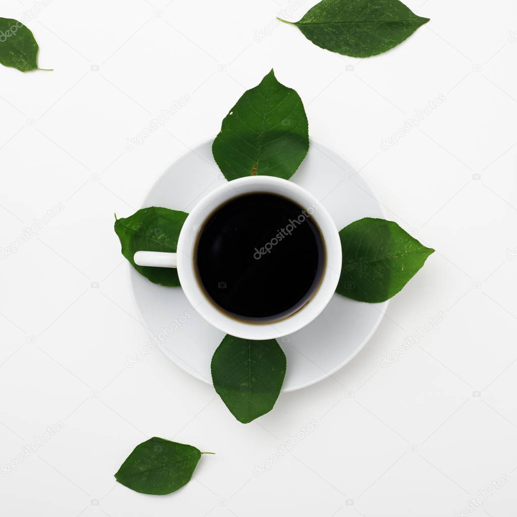 Top view of coffee on white background with fresh leaves