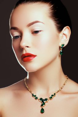 Takı ile lüks kız portresi. Pahalı küpe modeli kız. Zümrüt kolye ile güzel bir kadın. Güzellik genç model zümrüt kolye ile. Takı ve aksesuar. Güzellik Salonu