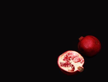 Düz yatıyordu. Üstten Görünüm. Pop art. Minimalist sanat. iki yarım nar meyve siyah tablo üzerinde yatıyordu