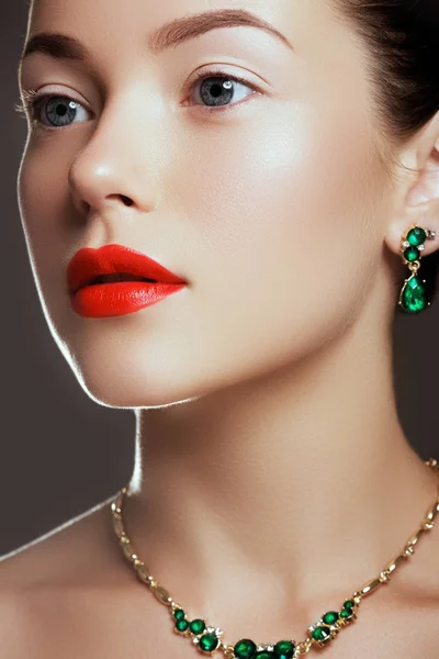 Porträtt av lyx kvinna med smycken. Modell i dyra örhängen. Vacker kvinna med emerald halsband. Beauty ung modell med emerald taklampa. Smycken och accessoarer. Mode och skönhetssalong — Stockfoto