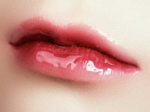 Gros plan belles lèvres féminines avec un maquillage brillant à lèvres. Une peau propre et parfaite, un maquillage des lèvres léger et frais. Belle macro shot spa avec gloss lèvres rose tendre. Spa et cosmétiques — Photo