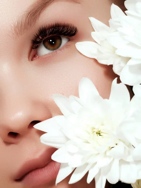 Giovane donna di bellezza con i fiori trucco primo piano. Cosmetici e trucco. Macro primo piano della moda visage — Foto Stock