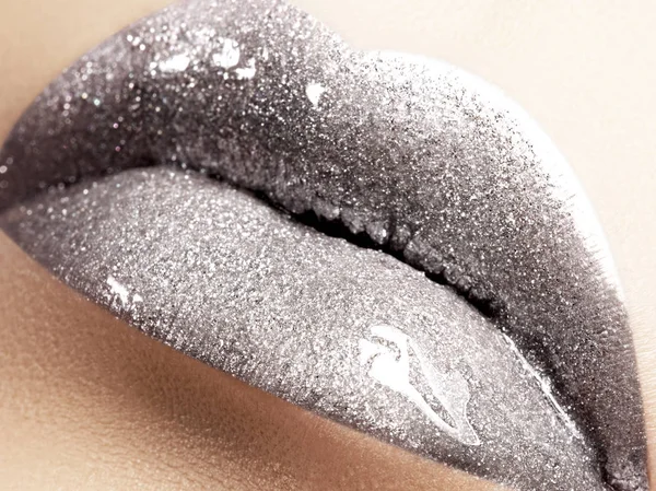 Close-up of liquid silver woman lips with glittering silver. Glittering Lips. Fashion Make-up