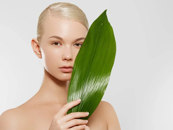 Cuidado de la piel, Bienestar, Spa. Piel suave y limpia, aspecto fresco y saludable. El concepto de una piel sana. Retrato de una hermosa niña sobre un fondo de hojas tropicales. Concepto Spa. Belleza natural — Foto de Stock