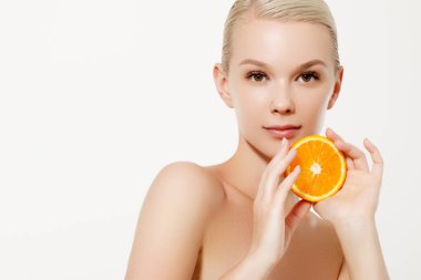 Taze meyve ile gülümseyen kız. Güzellik modeli sulu portakal alır. Çiller ile neşeli kız. Sağlıklı bir diyet kavramı. Profesyonel makyaj. Portakal dilim