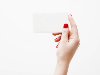 Düz yatıyordu, en iyi görünüm. Güzellik ve moda kavramı. Güzel eller kırmızı manikür ile. En az tarzı. Minimalist fotoğraf. Beyaz arka plan üzerinde kart tutan kız el ile soluk kompozisyon