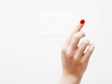 Düz yatıyordu, en iyi görünüm. Güzellik ve moda kavramı. Güzel eller kırmızı manikür ile. En az tarzı. Minimalist fotoğraf. Beyaz arka plan üzerinde kart tutan kız el ile soluk kompozisyon