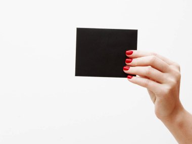 Düz yatıyordu, en iyi görünüm. Güzellik ve moda kavramı. Güzel eller kırmızı manikür ile. En az tarzı. Minimalist fotoğraf. Beyaz arka plan üzerinde indirim kartı tutan kız el ile kompozisyon