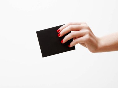 Düz yatıyordu, en iyi görünüm. Güzellik ve moda kavramı. Güzel eller kırmızı manikür ile. En az tarzı. Minimalist fotoğraf. Beyaz arka plan üzerinde indirim kartı tutan kız el ile kompozisyon