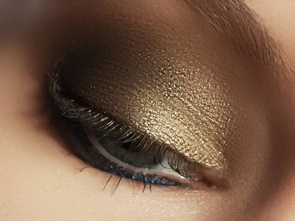 Nahaufnahme von blauen Frauenaugen mit schönen goldenen Farbtönen Make-up. Klassisches Make-up. Perfektes Make-up und lange Wimpern. Kosmetik und Make-up. Nahaufnahme Makroaufnahme der Mode Augen Visage — Stockfoto