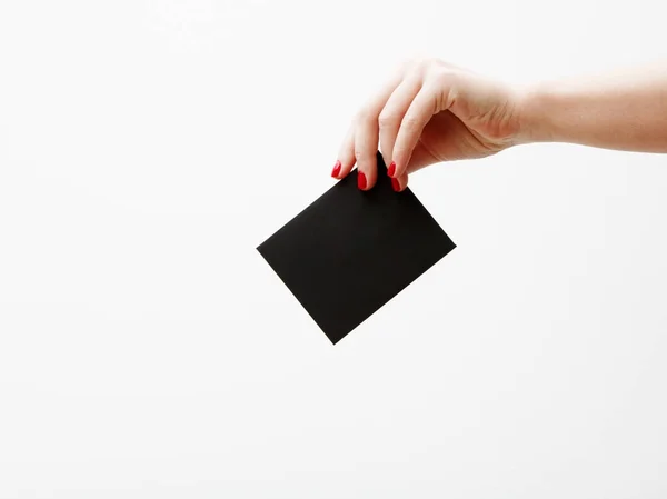 Flat lay, top view. Beauty and fashion concept. Beautiful female hands with red manicure. Minimal style. Minimalist photography. Composition with girl's hand holding discount card on white background — Stock Photo, Image