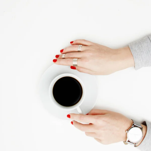 Acostado. Vista superior. Estilo mínimo. Moda minimalista y fotografía de belleza. De buen humor. Una chica en una manicura suéter sostiene una taza de café blanco sobre un fondo de mesa blanco. Relojes y joyas — Foto de Stock