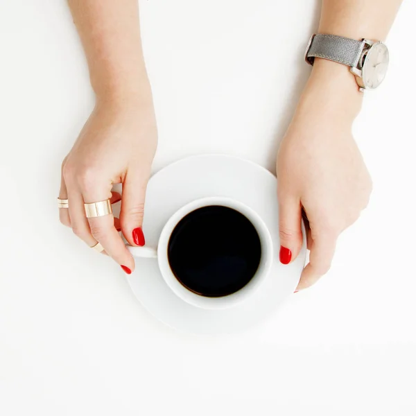 Acostado. Vista superior. Estilo mínimo. Moda minimalista y fotografía de belleza. De buen humor. Una chica en una manicura suéter sostiene una taza de café blanco sobre un fondo de mesa blanco. Relojes y joyas — Foto de Stock