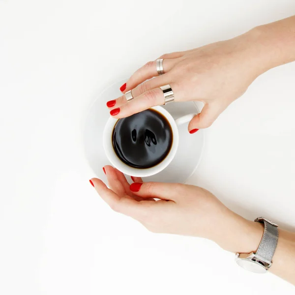 Acostado. Vista superior. Estilo mínimo. Moda minimalista y fotografía de belleza. De buen humor. Una chica en una manicura suéter sostiene una taza de café blanco sobre un fondo de mesa blanco. Relojes y joyas — Foto de Stock