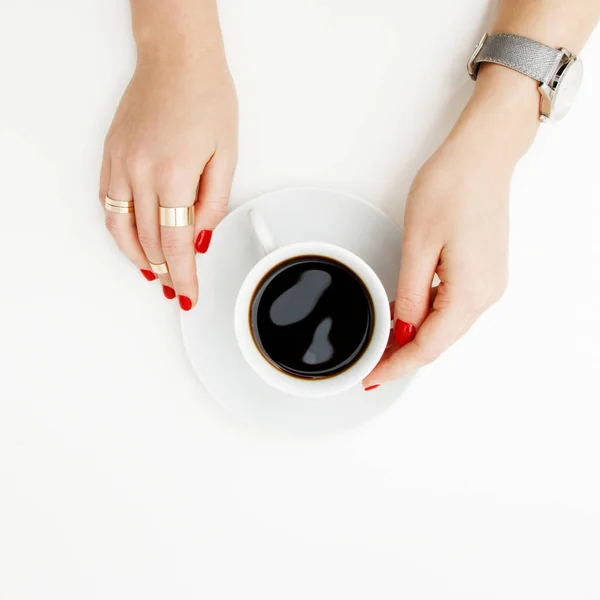 Acostado. Vista superior. Estilo mínimo. Moda minimalista y fotografía de belleza. De buen humor. Una chica en una manicura suéter sostiene una taza de café blanco sobre un fondo de mesa blanco. Relojes y joyas — Foto de Stock