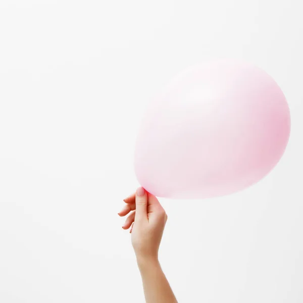 Minimalistische mode en beauty foto. Hand met een roze ballon op een witte muur achtergrond met schaduw reflectie. Het concept van St. Valentine's Day of verjaardag. 14 februari — Stockfoto